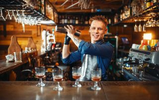 Bartender mit Cocktailshaker an der Bar - Cocktailkurs