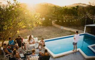 Freunde sitzen zusammen neben dem Pool im Sommer