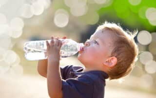 Junge trinkt aus einer Wasserflasche