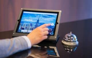 Hotelmitarbeiter bedient Tablet an der Rezeption eines Hotels