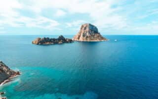 Blick über türkisfarbenes Wasser auf Inseln vor Ibiza