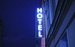 blau leuchtendes Hotel Neonschild an Geböude bei Nacht