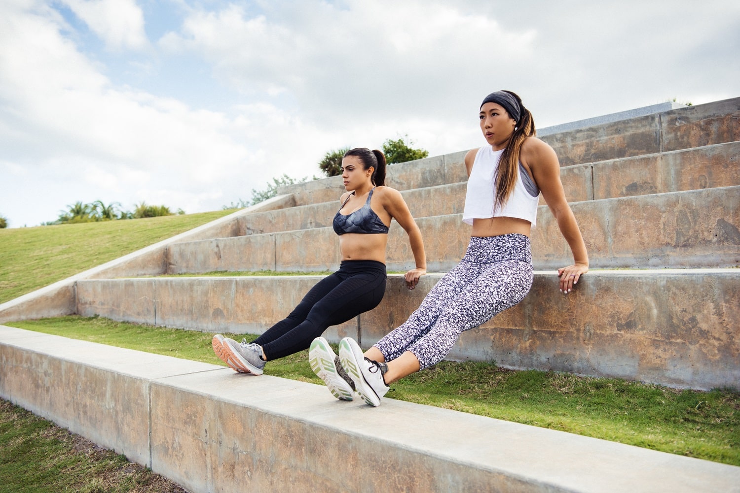 Two young women exercising outdoors, doing push-ups on steps, South Point Park, Miami Beach, Florida, USA