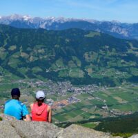 Wanderpaar bei einer Rast mit Aussicht auf das Zillertal