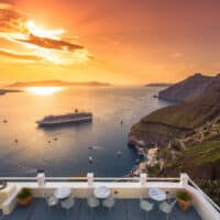 Sonnenuntergang auf Sanorini in Fira mit Blick aufs Meer und ein Kreuzfahrtschiff