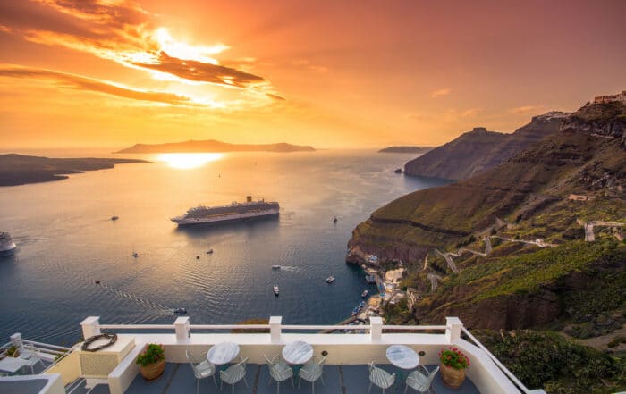 Sonnenuntergang auf Sanorini in Fira mit Blick aufs Meer und ein Kreuzfahrtschiff