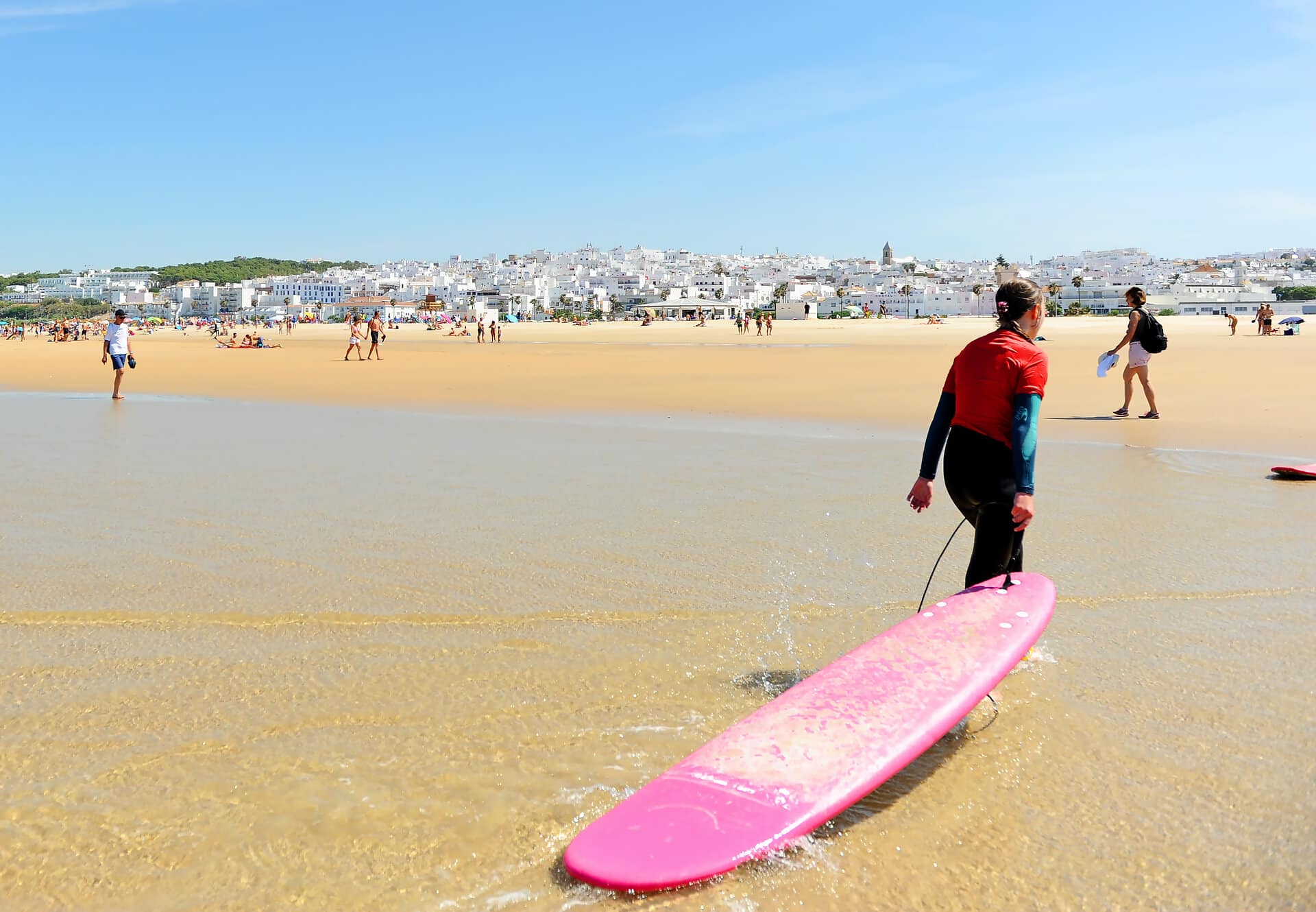 Surferin mit Board am Strand von Conil de la Frontera