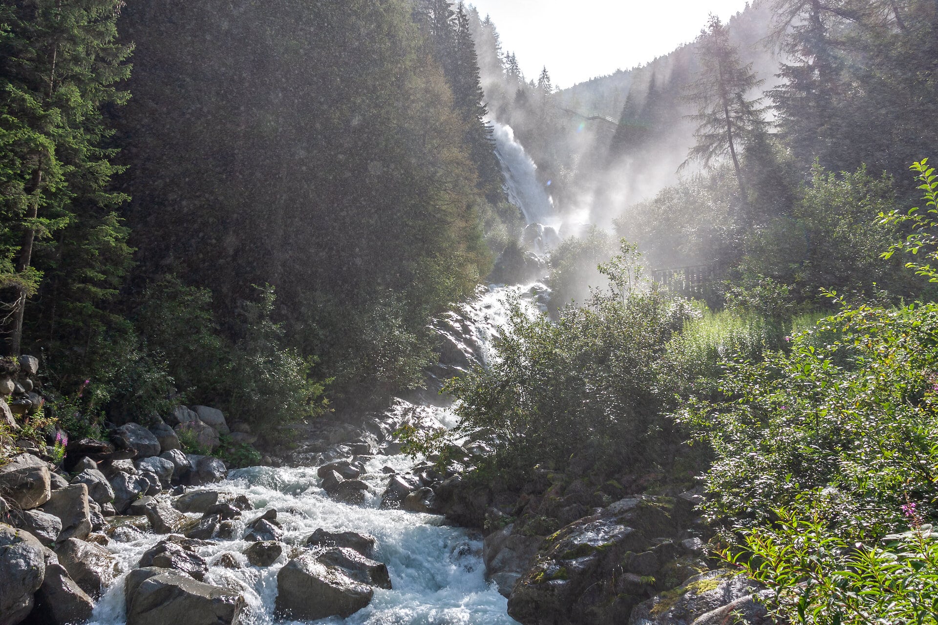 Wasserfall mit rauschendem Bach in grünem Tal