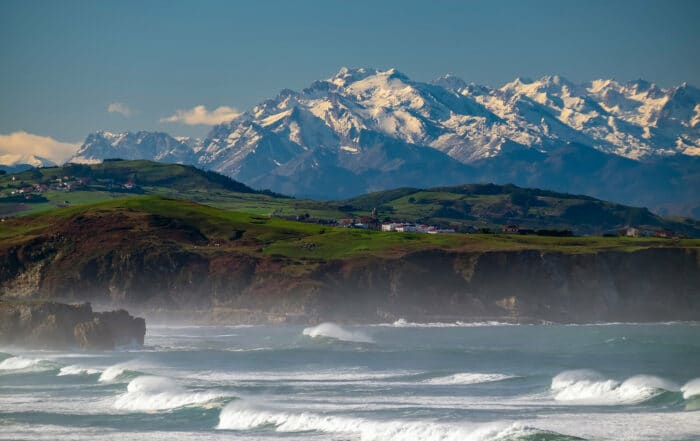 Küste Kantabriens in Norspanien mit den verschneiten Gipfeln der Picos de Europa im Hintergrund