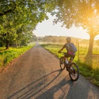 Radfahrerin auf idyllischem Weg im Spätsommer