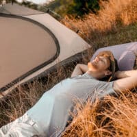 Sleeping man. A man laying on the grass near his tent and sleeping