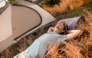 Sleeping man. A man laying on the grass near his tent and sleeping