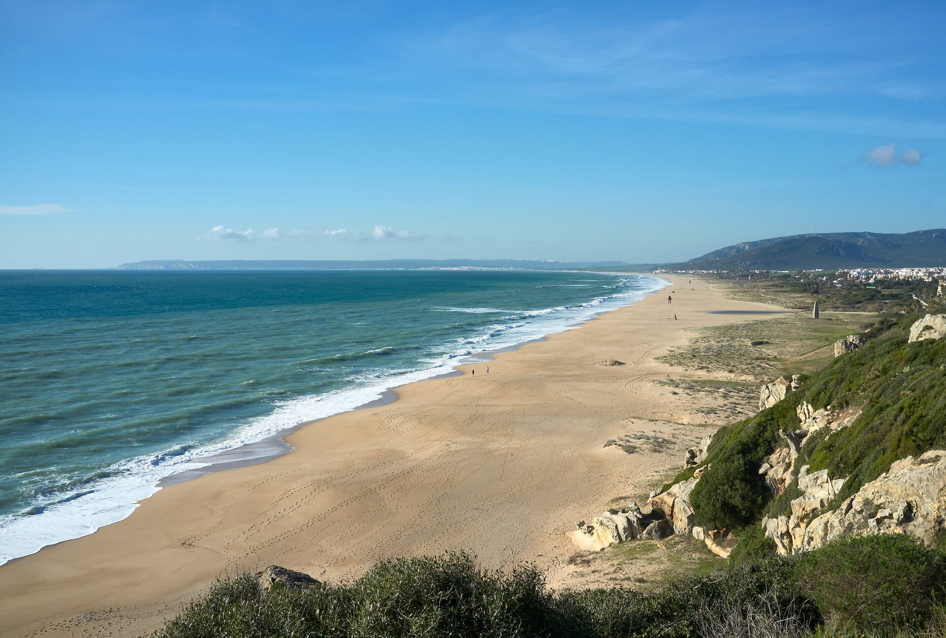 Amazing aerial view of a wild sandy beach. Magnificent scenery of the Atlantic ocean and long sandy shoreline on sunny day in Zahara de los Atunes, Cadiz, Andalusia, Spain