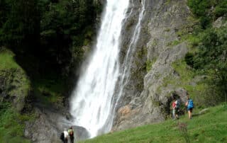 2 Wanderpaare bestaunen den Parschinser Wasserfall in Südtirol