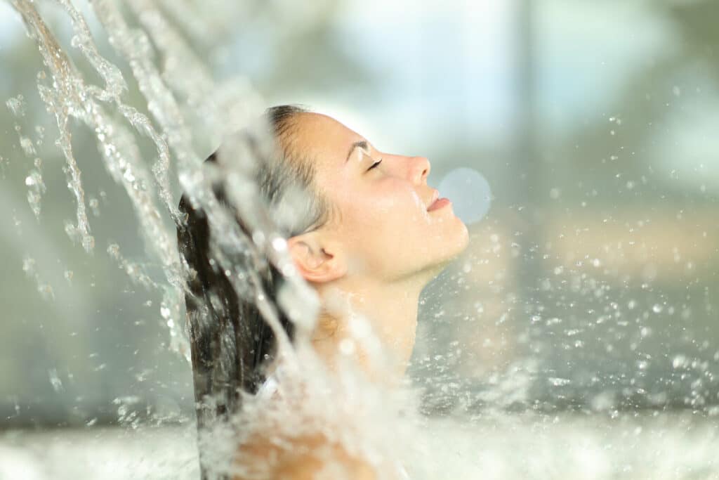 Frau genießt Wasserfall im Spa