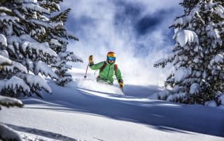 Skifahren: Skifahrer fährt durch tiefen Neuschnee