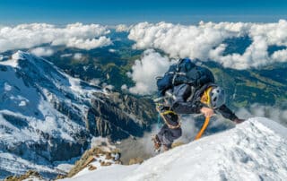 Bersteiger klettert steilen Schneehang am Mont Blanc Massiv empor