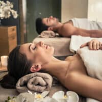 Mann und Frau auf Massageliegen im Spa